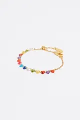 Pulsera de cadena fina dorada de acero inoxidable con una hilera de cristales de vidrio en forma de corazón de múltiples colores. Incluye cierre de mosquetón ajustable y dije de la marca.