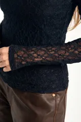 Remera de encaje negro ajustada al cuerpo, de manga larga y diseño transparente.