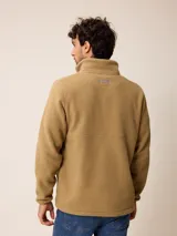 Campera de polar tipo sherpa en color azul, con cierre frontal completo, cuello alto y bolsillos laterales. Presenta un pequeño logo bordado en el pecho.