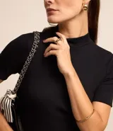 Blusa de corte regular confeccionada en tejido de rib acanalado color naranja. Presenta cuello alto y mangas cortas.