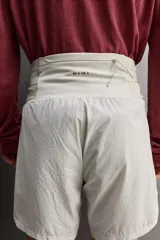 Short deportivo de trail running confeccionado en tejido técnico elástico con textura. Presenta una cintura elástica ancha con compartimentos integrados, bolsillo trasero con cierre y aberturas laterales en el bajo.