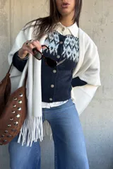 Cardigan de punto en color azul marino con diseño jacquard en tonos celestes y blancos en la parte superior. Presenta cuello redondo, cierre frontal con botones y mangas largas.