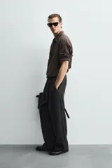 Camisa de corte relajado confeccionada en tejido ligero de algodón con textura de cuadros. Presenta cuello solapa, manga larga con puños abotonados y cierre frontal de botones.