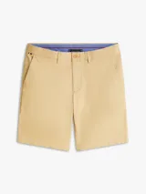 Pantalón chino corto Tommy Hilfiger de corte regular y pierna recta, confeccionado en mezcla de algodón orgánico, algodón y elastano. Cuenta con dos bolsillos delanteros en diagonal y dos bolsillos traseros de ojal con botón.