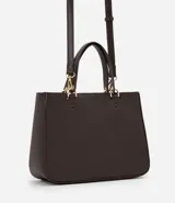 Cartera satchel mediana color beige, con cierre de cremallera, correa de mano y bretel largo desmontable. Incluye un llavero de pompón de piel sintética.