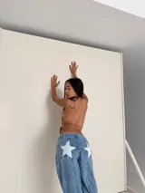 Pantalón de jean celeste con apliques de estrellas blancas en la parte trasera.