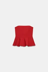 Top rojo sin tirantes, de escote recto y hombros descubiertos, con diseño ajustado en el torso y bajo acabado con peplum. Cierre lateral con cremallera oculta.