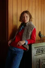 Chaleco tejido de punto en color taupe, con textura rústica y diseño sin mangas. Presenta un corte recto y abierto al frente, ideal para superponer sobre otras prendas.