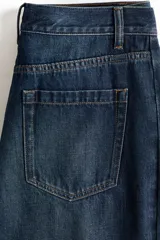Jean de denim azul oscuro con diseño de piernas curvas y corte holgado de tiro medio.