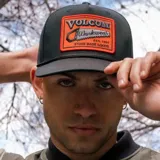 Gorro trucker negro de Volcom con paneles frontales rígidos, visera curva y paneles traseros de malla. Presenta un parche bordado con el logo de Volcom y una sierra en la parte delantera.