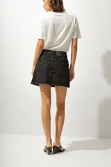 Minifalda de jean color negro con lavado gastado, corte recto y tiro alto.