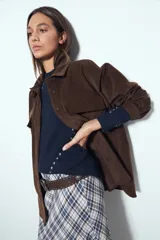 Sobrecamisa de pana color marrón oscuro, con diseño de corte amplio, cuello camisero, cierre frontal con botones y bolsillos con solapa en el pecho.