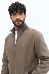 Campera de algodón con cierre frontal, cuello alto en color verde oliva y cuerpo texturado con patrón de espiga en tono marrón topo. Las mangas son lisas y del mismo tono que el cuerpo. Presenta un pequeño logo bordado en el pecho.