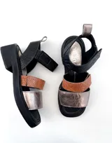 Sandalias de cuero multicolor (negro, marrón y dorado) con tiras ajustables con velcro y suela de goma. Elaboradas artesanalmente en Uruguay.
