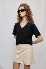 Falda short de tiro medio con diseño cruzado en el frente, que aporta la apariencia de una falda manteniendo la comodidad del short. Presenta cintura definida, líneas simples y un calce que acompaña suavemente la silueta.