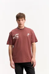 Remera oversize de algodón y poliéster color marrón, con cuello redondo, mangas cortas y estampa frontal con la inscripción "STREET VIBE DIVISION".