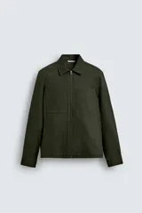 Sobrecamisa de hombre color verde militar, de corte relajado, con cuello solapa, cierre frontal de cremallera, bolsillos de plastrón en el pecho y bolsillos de vivo en la cadera.