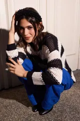 Sweater ligero de punto bicolor a rayas horizontales blancas y negras, con diseño holgado, mangas largas y detalles de costuras en zigzag a contratono.