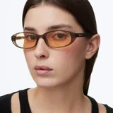 Lentes de sol con montura ovalada color camel translúcido y cristales amarillos. Cuentan con protección UV400 categoría 2, lentes polarizadas con recubrimiento resistente a rayones y tratamiento hidrofóbico.