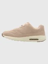 Zapatillas urbanas Hush Puppies modelo Brandhall, confeccionadas en cuero descarne color taupe. Presentan diseño con cordones, suela de EVA con tecnología de amortiguación de aire y detalles de la marca en el lateral y la lengüeta.