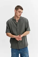 Camisa de manga corta verde militar con tejido calado de líneas verticales, cuello abierto estilo resort y cierre frontal con botones.