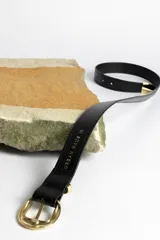 Cinturón marrón con hebilla dorada.