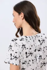 Blusa manga corta de cuello redondo con estampado floral en blanco y negro.