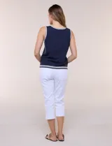 Musculosa de tejido de punto color azul marino, de corte recto, con cuello redondo y sisa amplia. Presenta detalles de líneas en contraste de color blanco en el cuello, las sisas y el ruedo.