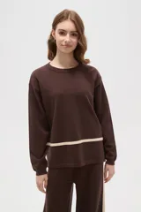 Sweater de tejido de punto color marrón, de corte holgado y cuello redondo, con detalle de franja horizontal en color crema en la parte inferior.