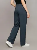 Pantalón de vestir azul petróleo, de corte sastre y pierna ancha. Presenta bolsillos laterales, cierre con clip y cremallera. Confeccionado en poliéster reciclado, ecovero viscosa y elastano.