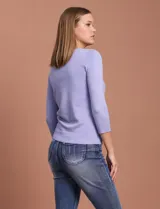 Cardigan blanco de tejido fino con abertura central y botones.