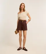 Short regular de talle alto confeccionado en sarga de color marrón, con trabillas para cinturón, cierre con botón y cremallera, bolsillos delanteros y traseros, y pespuntes en contraste.
