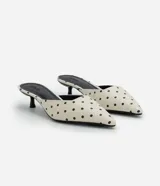 Zapato tipo mule de punta fina con estampado de lunares, diseño abierto en el talón y tacón bajo tipo kitten heel.