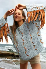 Sweater celeste de lana mohair con diseño de trenzas y apliques de cuero color suela.