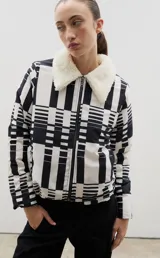 Campera con estampado de bosque en tonos azules, cuello de sherpa en color crema y cierre frontal con cremallera. Cuenta con elástico ajustable en la cintura.