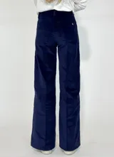 Pantalón de corte recto y tiro medio, confeccionado en pana color bordó. Presenta costuras verticales decorativas en el frente, cierre con botón y bolsillos laterales.