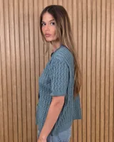 Cardigan calado de manga corta, tejido en punto con cierre frontal de botones y cuello redondo.