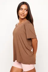 Remera de corte holgado y diseño minimalista, confeccionada en una mezcla de viscosa, lino y elastano. Presenta cuello redondo amplio y mangas cortas con terminación al corte.