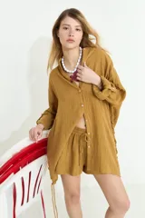Camisa de algodón blanca, de manga larga y corte oversize, con diseño abierto en los laterales ajustable mediante cordón y ojalillos.