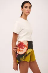 Pañuelo cuadrado de algodón con estampado de frutas y flores en tonos naranja, amarillo, verde y rojo sobre fondo negro.