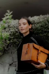 Buzo de punto color blanco con cuello alto y detalles de pespuntes decorativos en color negro en las costuras de los hombros, puños y ruedo.