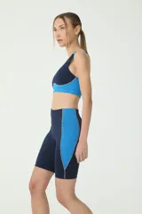 Biker deportivo azul con recortes azulinos y costuras en tono verde.