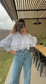 Camisa fucsia de popelina con volados en el frente y mangas largas.