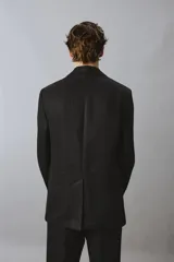 Blazer de corte regular confeccionado en lino, con solapas de muesca, cierre frontal de botones y múltiples bolsillos con solapa en la parte frontal. Presenta un diseño estructurado con abertura en la espalda y forro parcial.