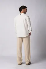 Camisa de manga larga confeccionada en lino, con cuello mao y cierre frontal de botones. Presenta un corte relajado y diseño minimalista.