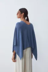 Poncho tejido de punto color azul con cuello en V y mangas amplias.