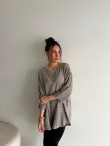 Blusa de viscosa con estampado de lunares, corte holgado, mangas tres cuartos y escote en V con botón central.