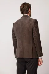 Blazer de corte slim fit confeccionado en pana de textura suave, con cierre frontal de dos botones, solapas clásicas y bolsillos laterales con solapa.