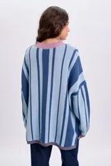 Sweater de punto con diseño de rayas verticales en tonos de azul y celeste, con cuello redondo en color rosado.