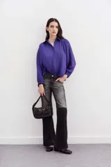 Camisa fluida de manga larga, color negro, con cuello camisero, puño con botón y detalle de frunces.